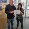 Entrega del dinero recaudado en el mercadillo de libros del director de la Biblioteca de Ciencias a la representante de la Fundación Illumináfrica
